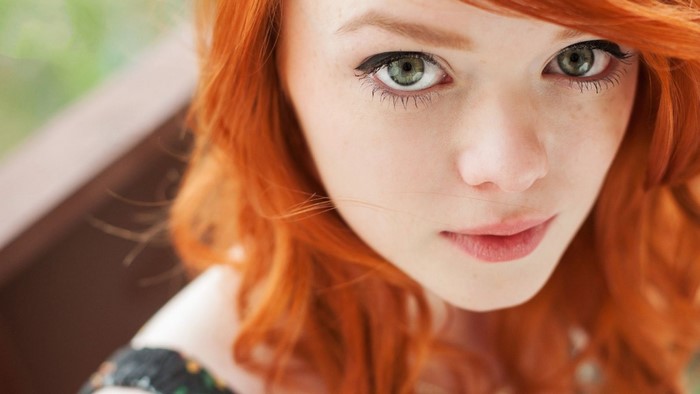 Redhead woman with green eyes close-up portrait