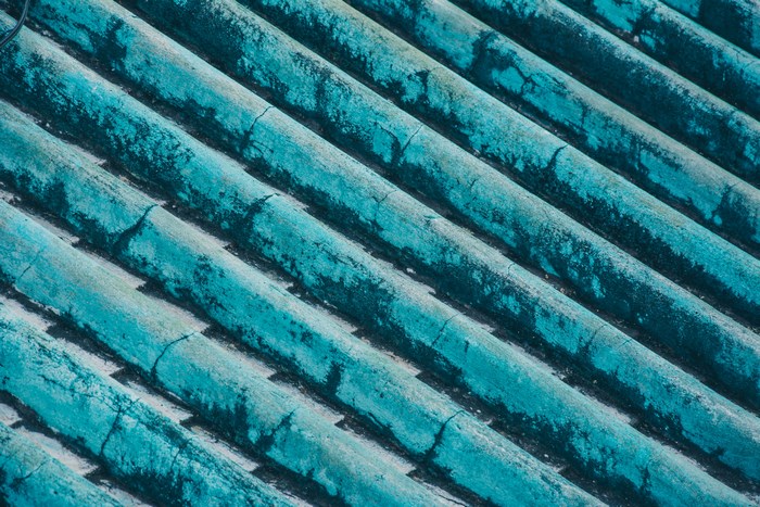 Close-up of weathered turquoise corrugated roof tiles