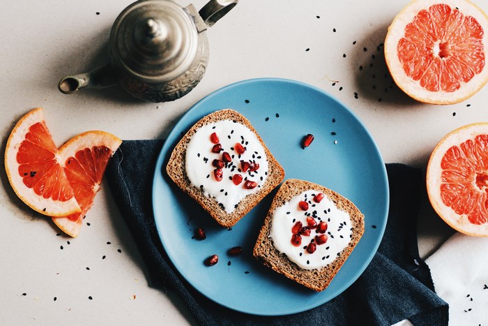 Grapefruit and toast with pomegranate seeds on a plate