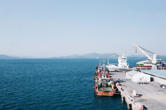 Boats docked at a harbor with mountains in the background