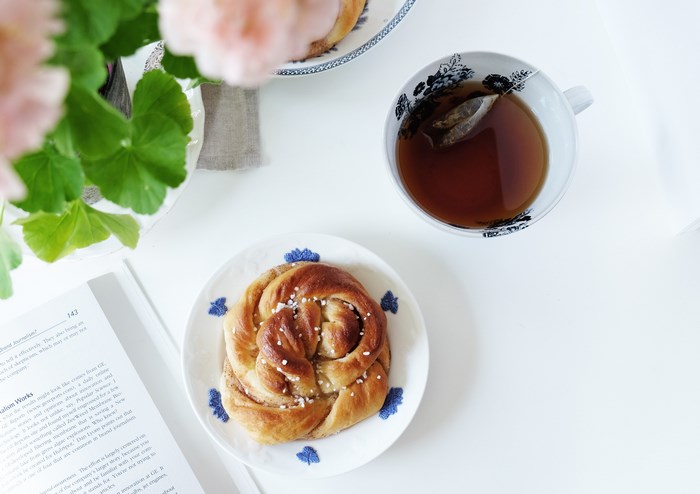 Cinnamon bun with tea and a book