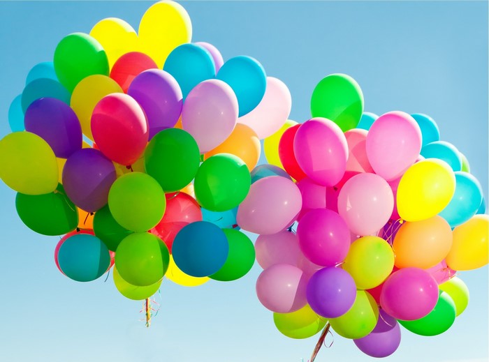 A large bunch of colorful balloons floating in the sky