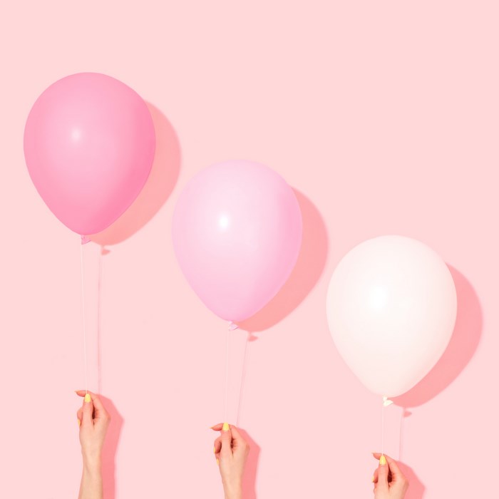 Three Hands Holding Pastel Pink Balloons