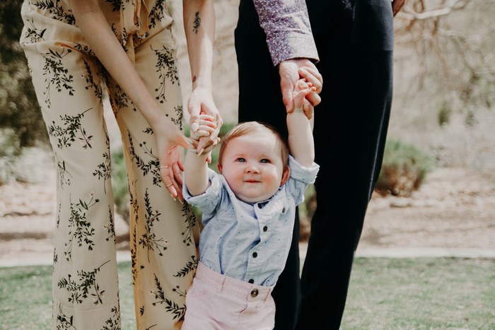 Family holding baby outdoors
