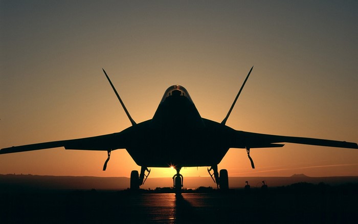 F-22 Raptor aircraft silhouette at sunset