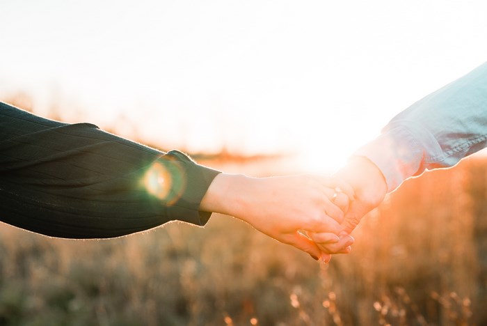 Couple holding hands at sunset