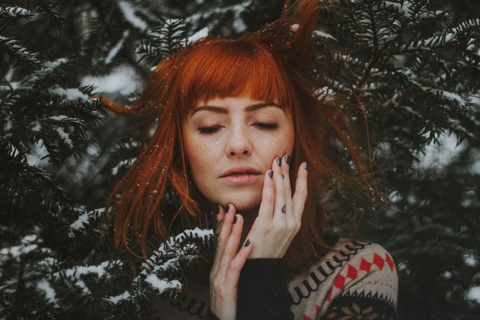 Woman with red hair and freckles in the snow
