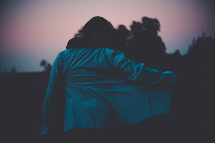 Person in a blue shirt in a dark outdoor setting