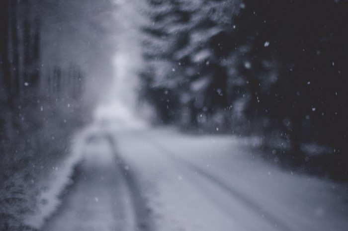Blurred snowy road in winter forest