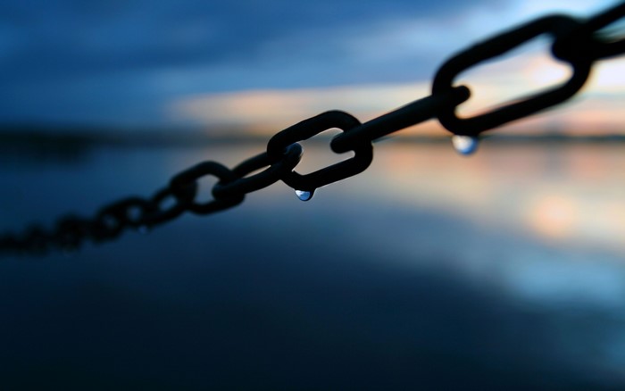 Chain with water drops over the sea at dusk