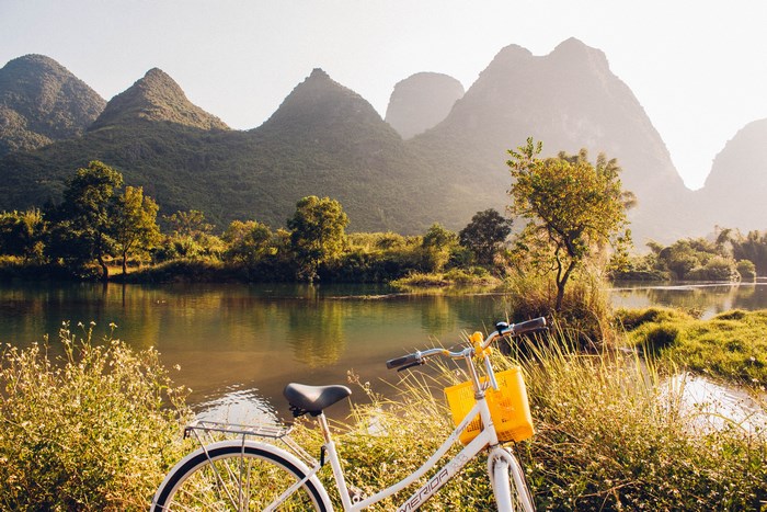 Bicycle by a river with karst mountains