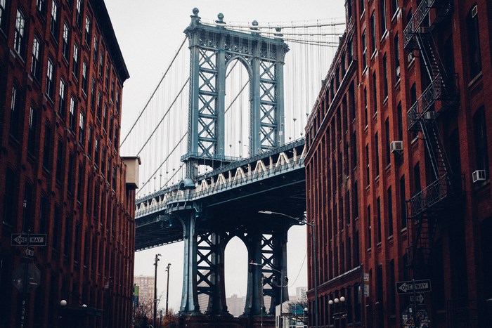 Manhattan Bridge between brick buildings in New York City