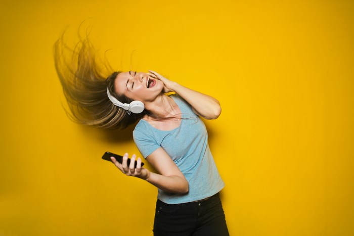 Woman with headphones listening to music on phone