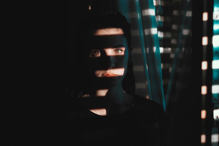 Woman with striped shadows on her face