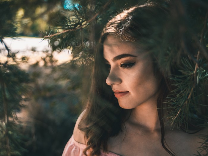 Young woman with makeup in pine trees