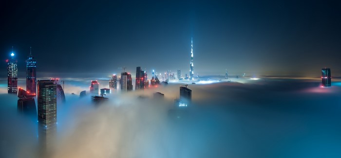Dubai skyline shrouded in mist at night with Burj Khalifa