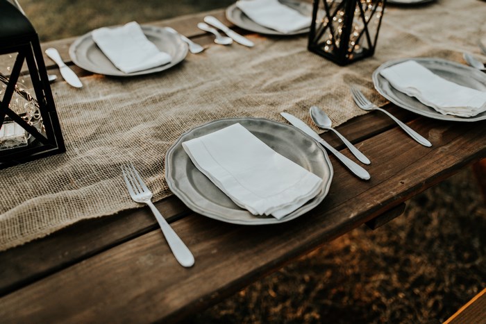 Table setting with plates, silverware, and lanterns