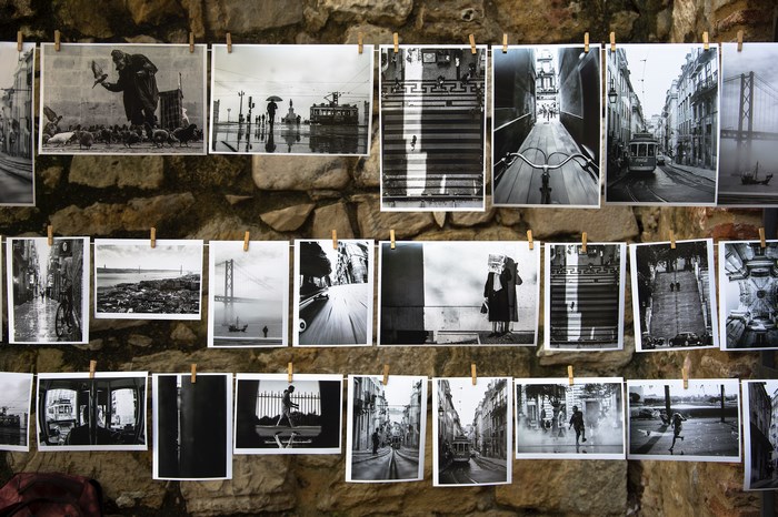 Collection of black and white photographs displayed on a stone wall