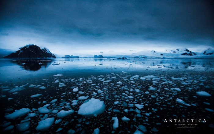 Antarctica icebergs and mountains reflected in the sea