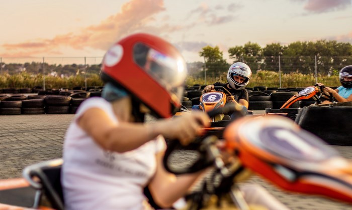 People racing go-karts at sunset