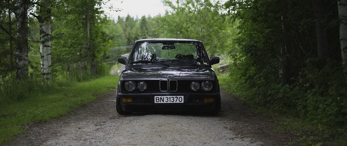 BMW E28 5 Series on a dirt road