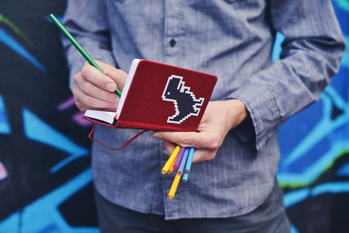 Man with a notebook and colored pencils