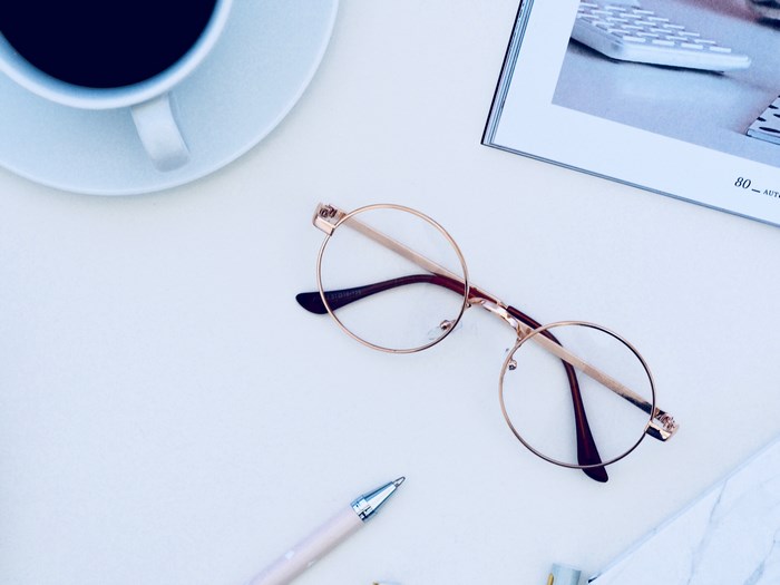 Minimalist desk with coffee, glasses, and pen