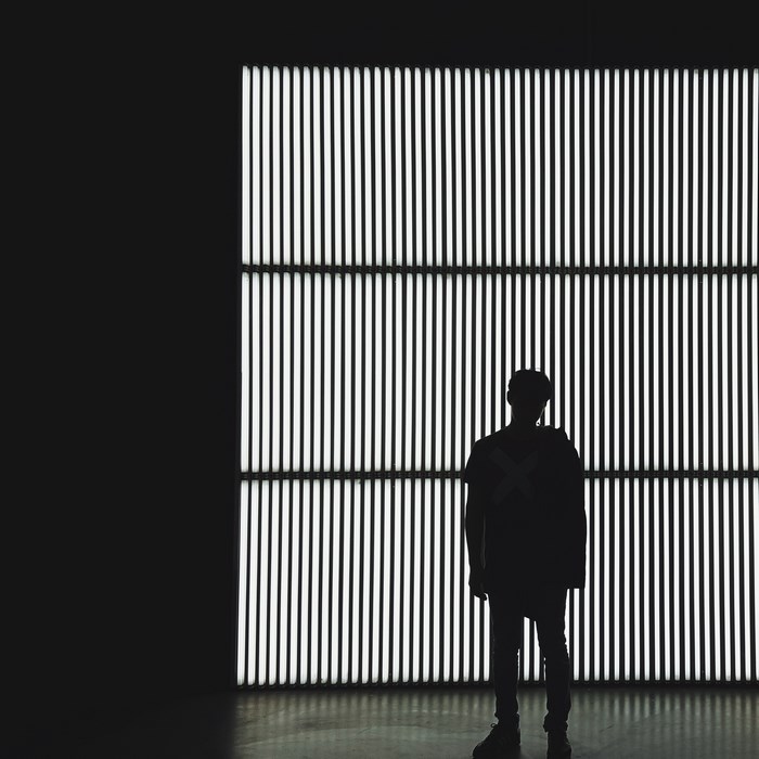Silhouette of a person against a wall of lights