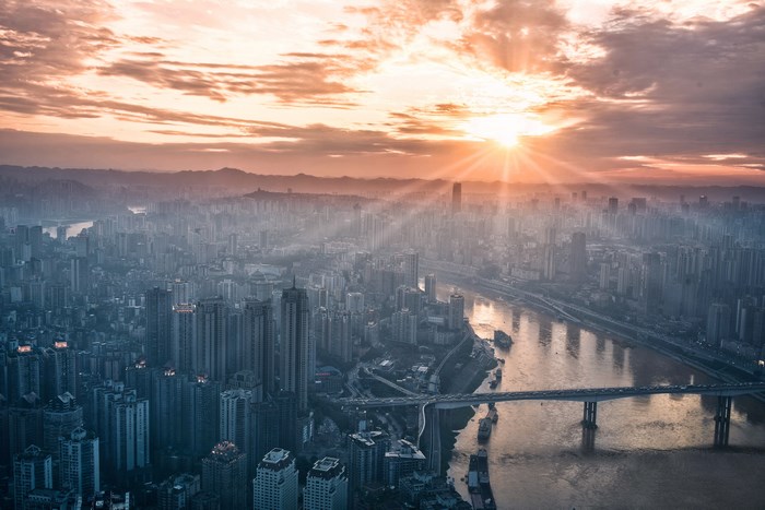 Cityscape with sun rays over a river and bridge