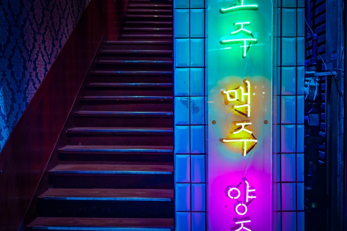 Neon sign on a staircase at night