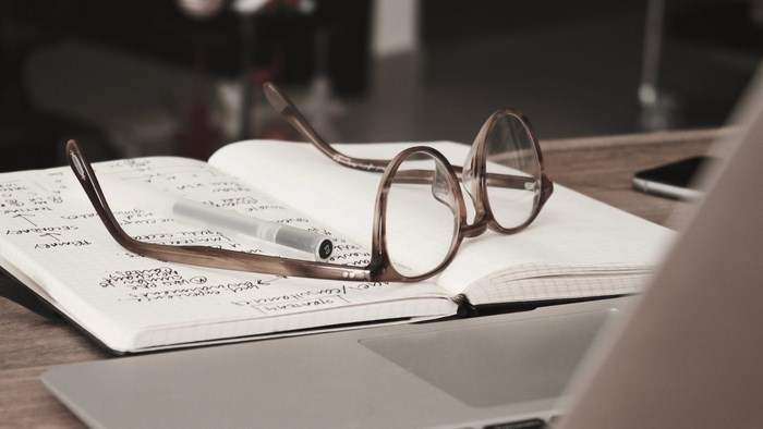 Glasses on notebook with laptop and smartphone