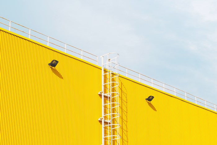 Yellow industrial building with ladder and lights