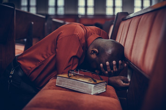 Man praying with Bible in church