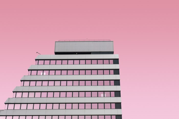 Modern building with pink windows against a pink sky