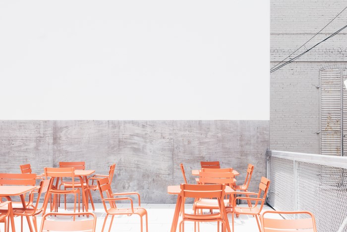 Orange tables and chairs on a rooftop patio