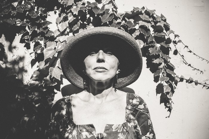 Elderly woman in a wide-brimmed hat and floral dress