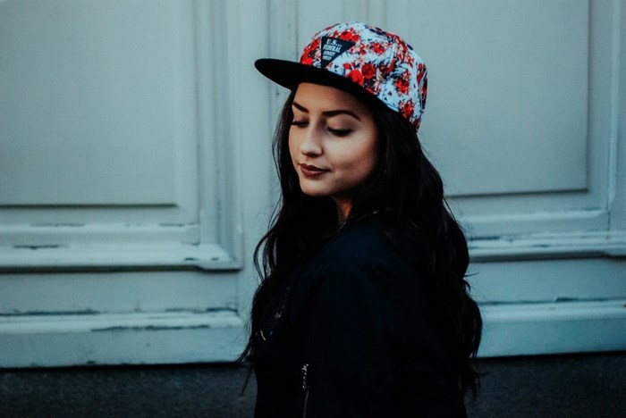 Woman wearing a floral cap and dark jacket