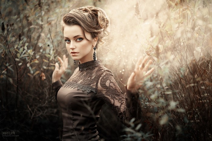 Woman in vintage dress with elaborate hairstyle outdoors