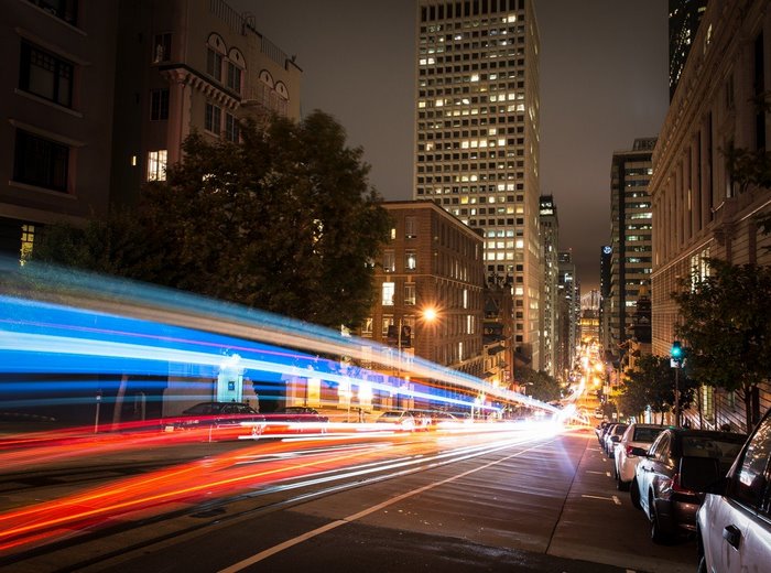 City street at night with light trails and buildings