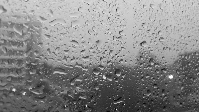 Raindrops on a window overlooking a city