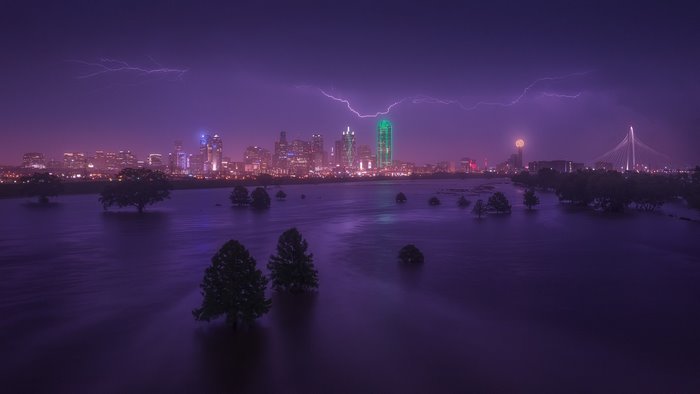 Dallas, Texas skyline during a lightning storm over flooded land