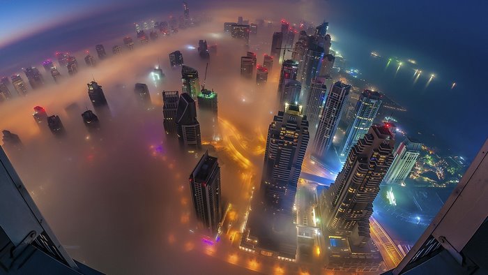 Aerial view of Dubai skyscrapers in fog at night