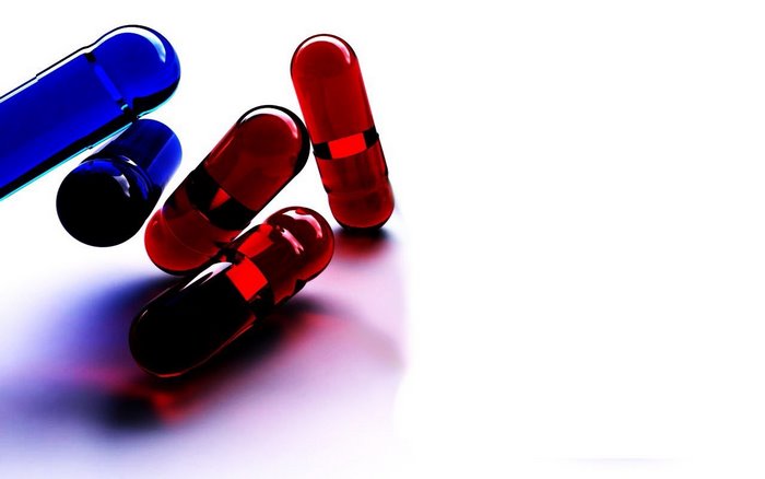 Red and blue pills on a white surface