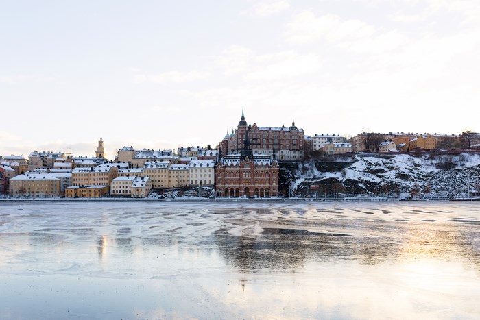 Stockholm waterfront with snow-covered buildings and icy river