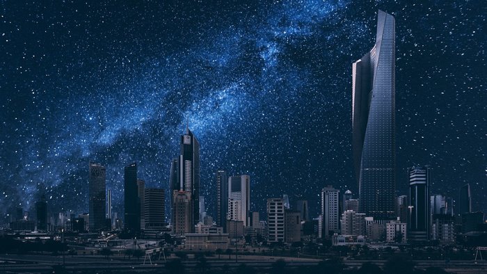 City skyline at night with Milky Way galaxy
