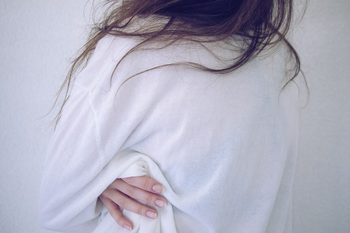 Person in white sweatshirt with messy hair