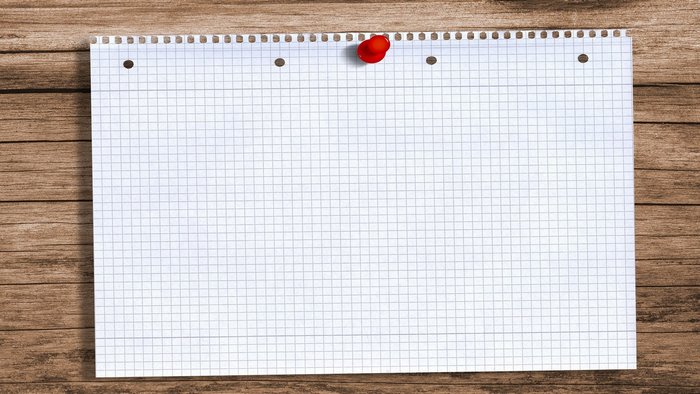Graph paper pinned to a wooden surface