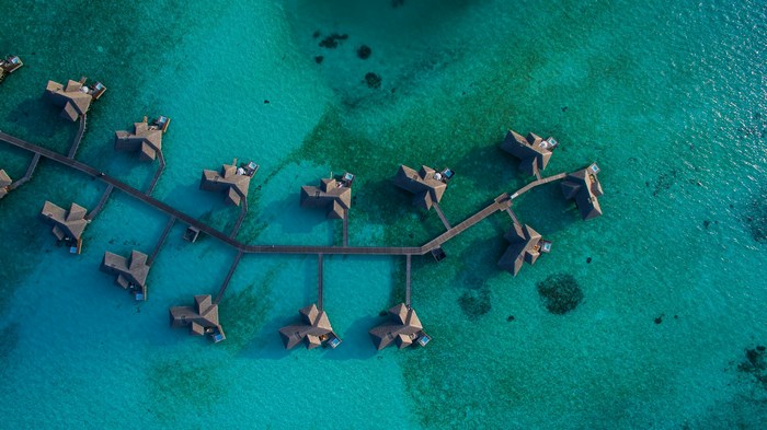 Aerial View of Overwater Villas on Turquoise Lagoon