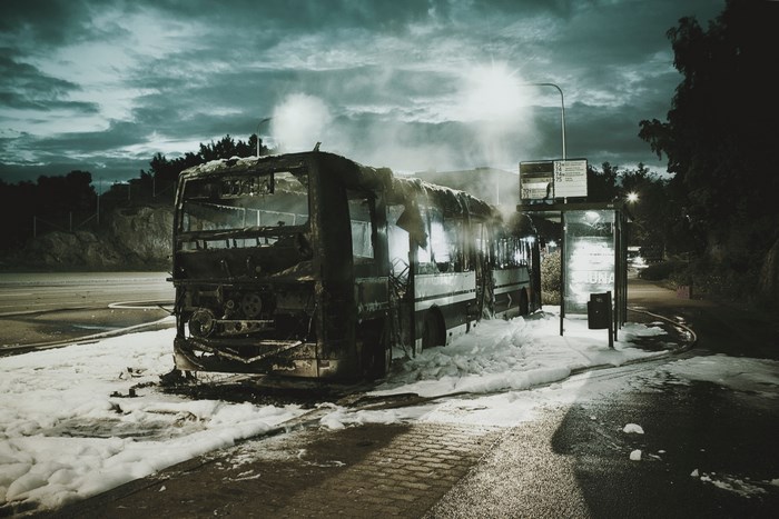 Burned bus at a bus stop with foam