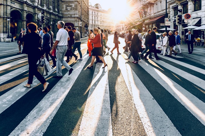 People crossing a street in Vienna at sunset